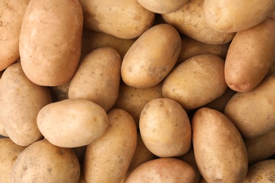 Photo of Fresh ripe organic potatoes as background, top view