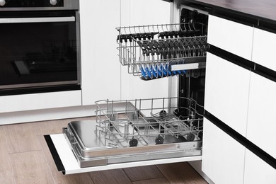 Open clean empty dishwasher in kitchen. Home appliance