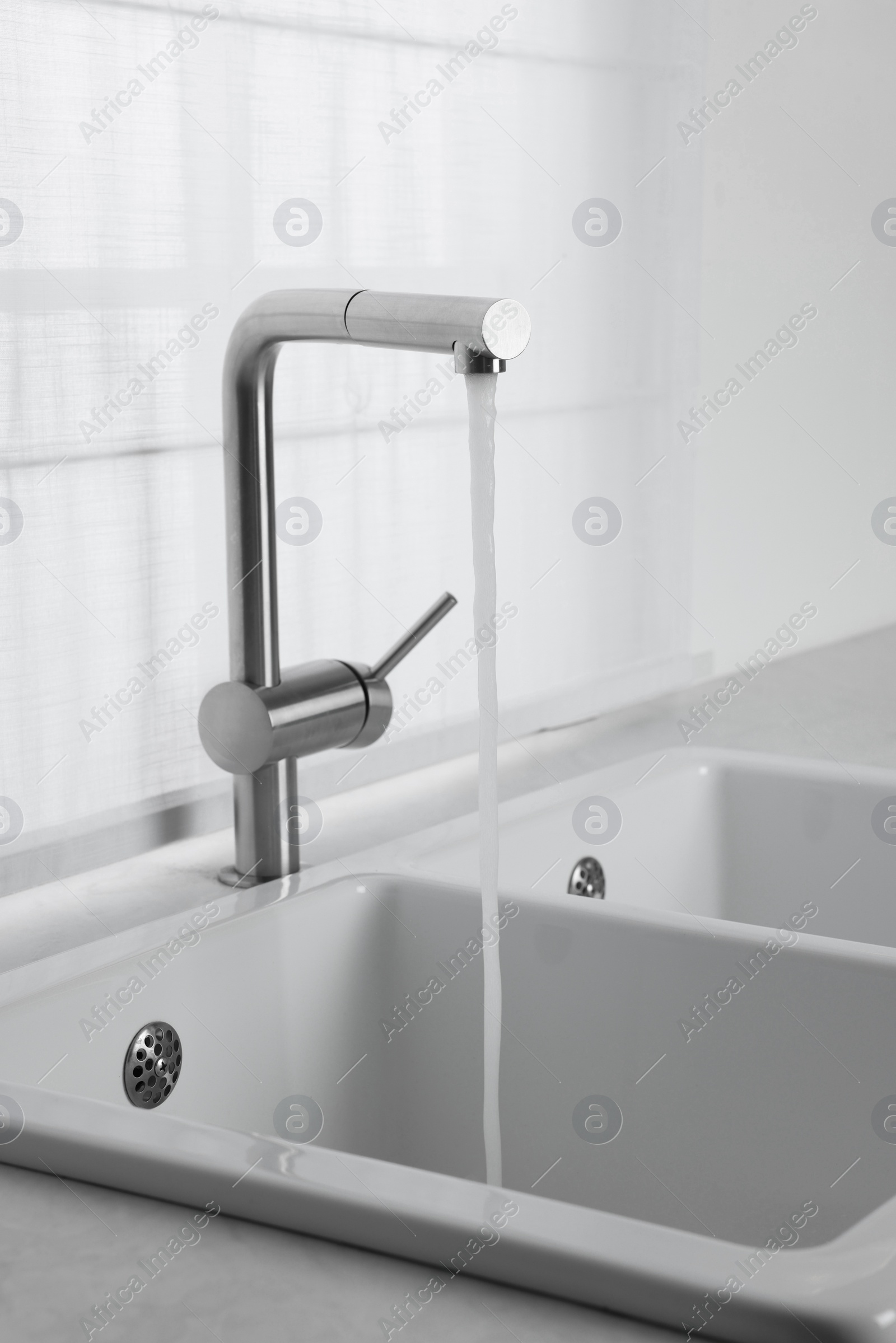 Photo of Stream of water flowing from tap in kitchen