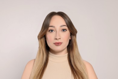 Young woman with lip piercing on white background