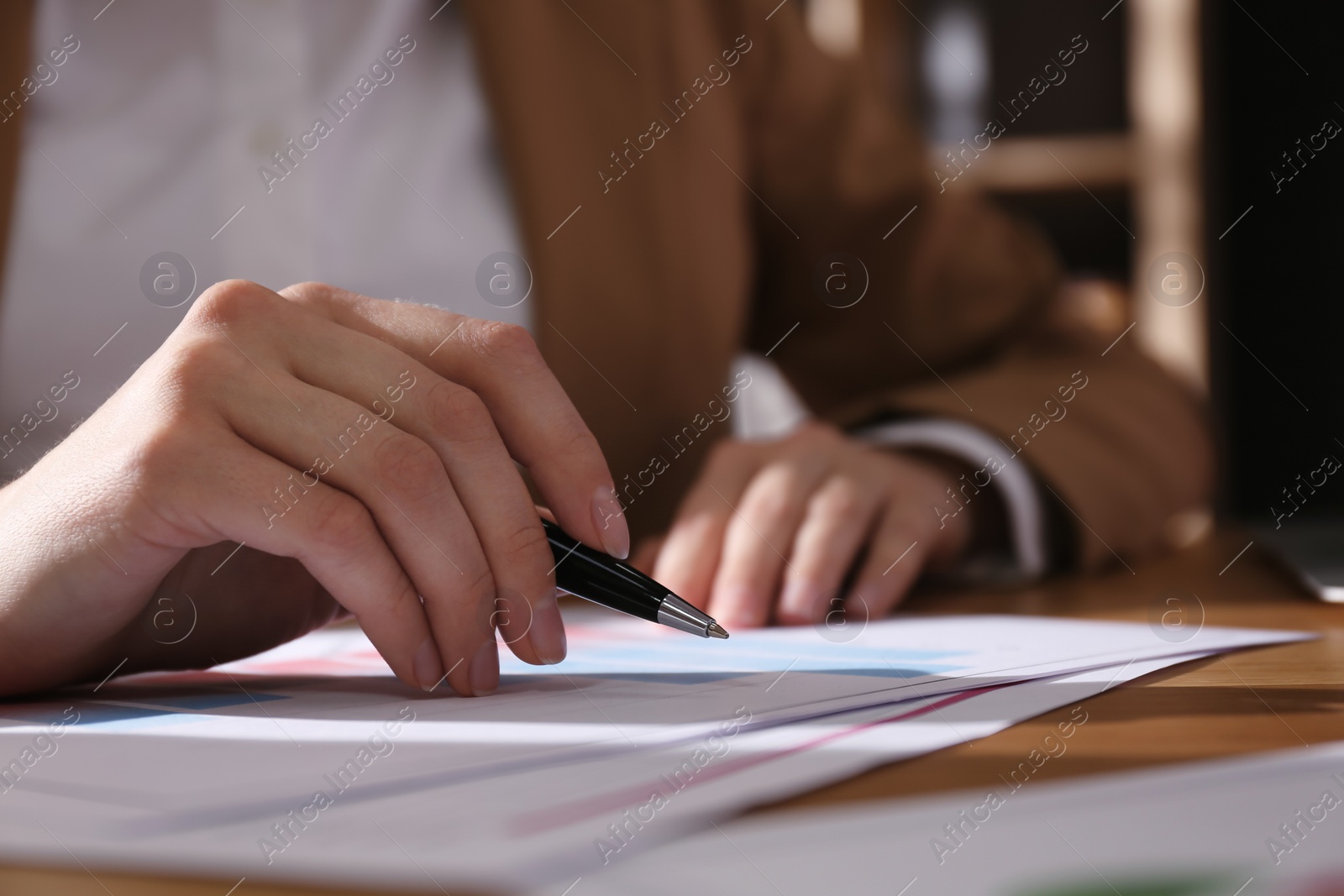 Photo of Businesswoman working with charts and graphs at table in office, closeup. Investment analysis