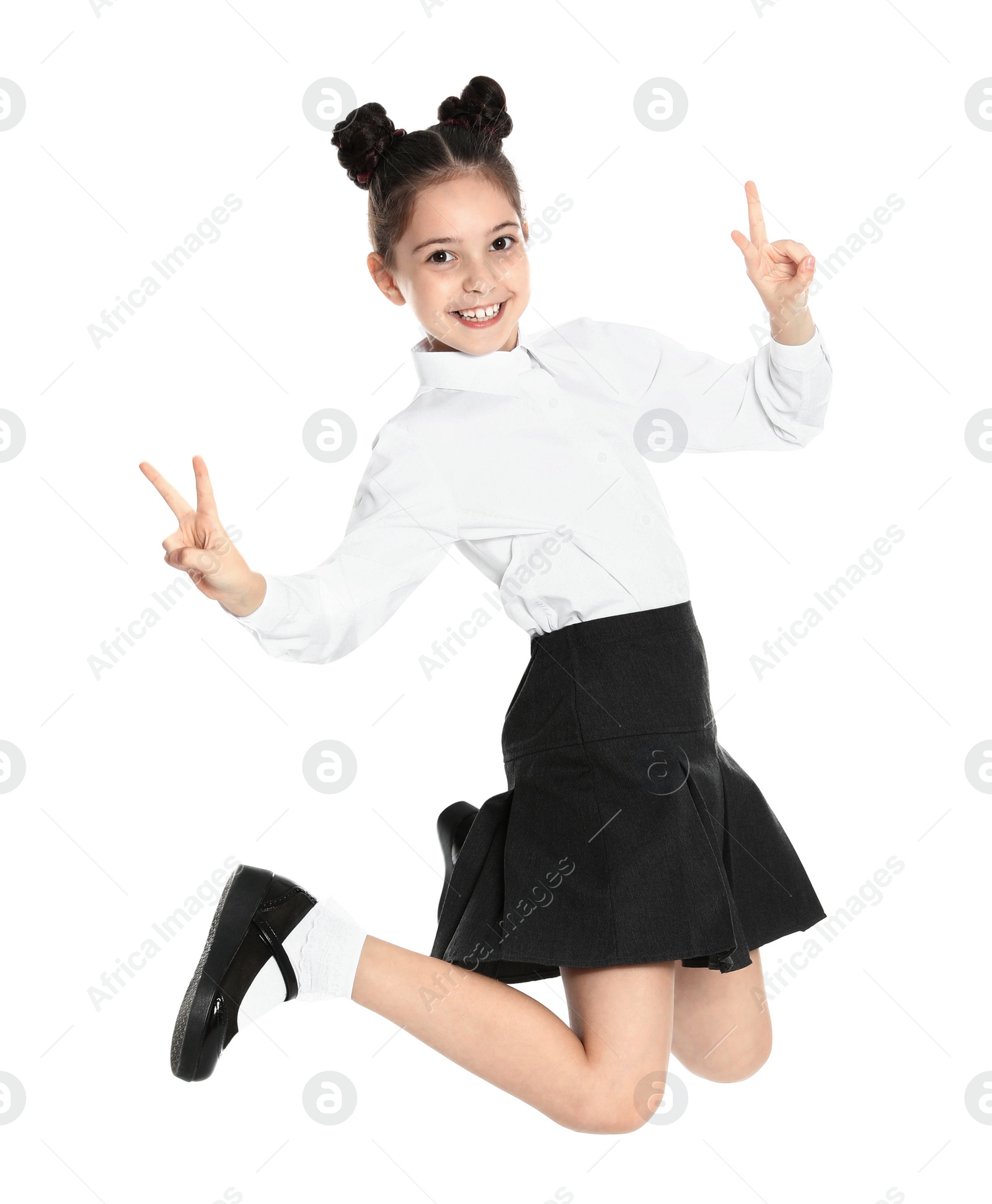 Photo of Happy girl in school uniform jumping on white background