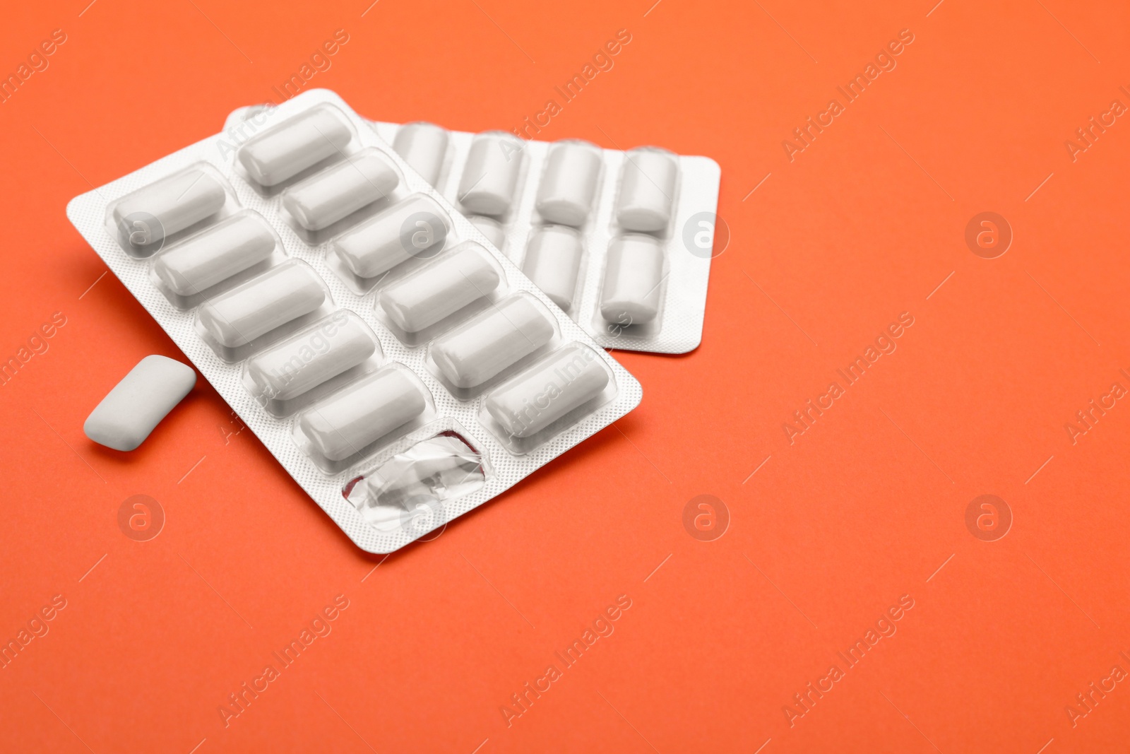 Photo of Blisters with chewing gums on orange background. Space for text