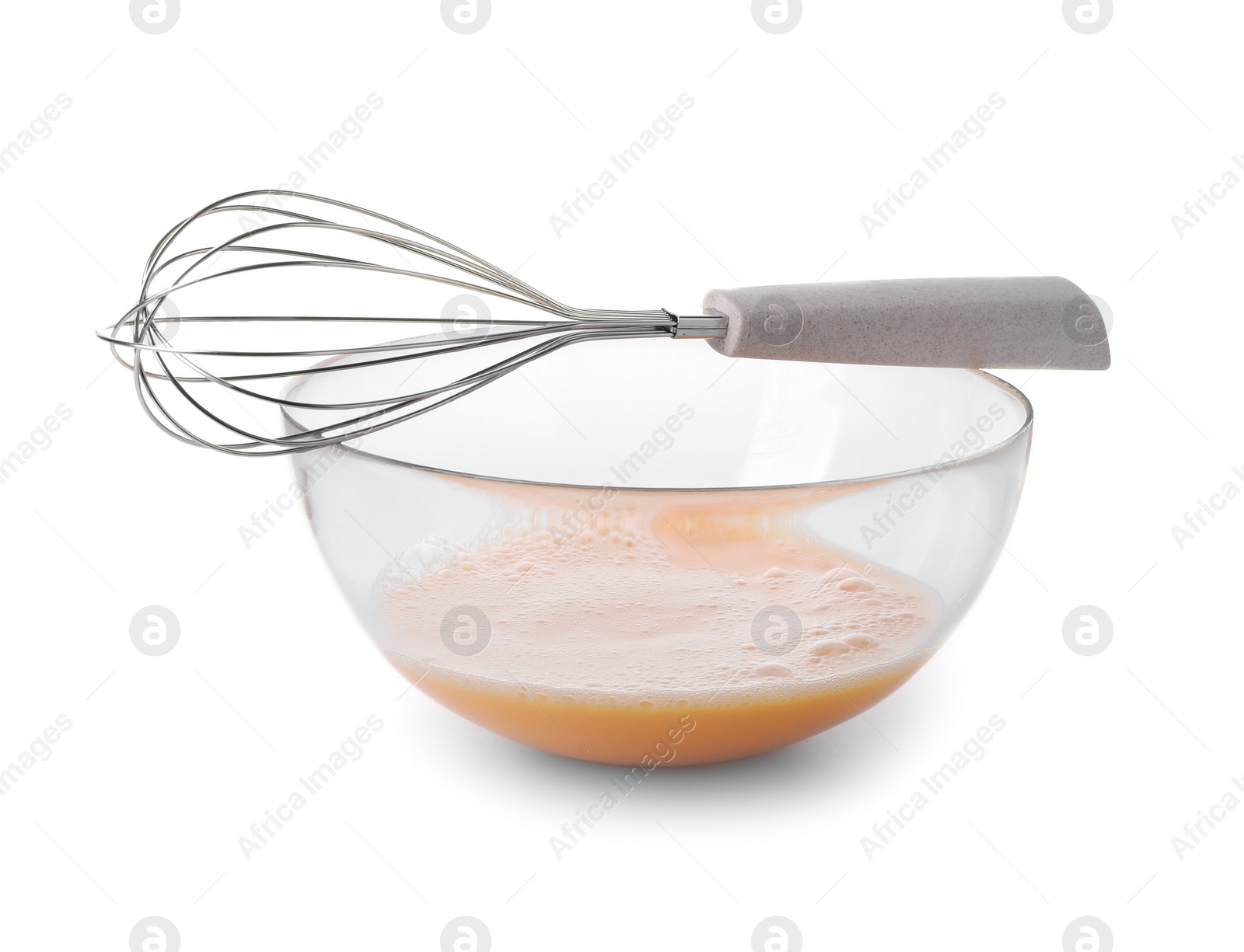 Photo of Beaten eggs in glass bowl and whisk isolated on white