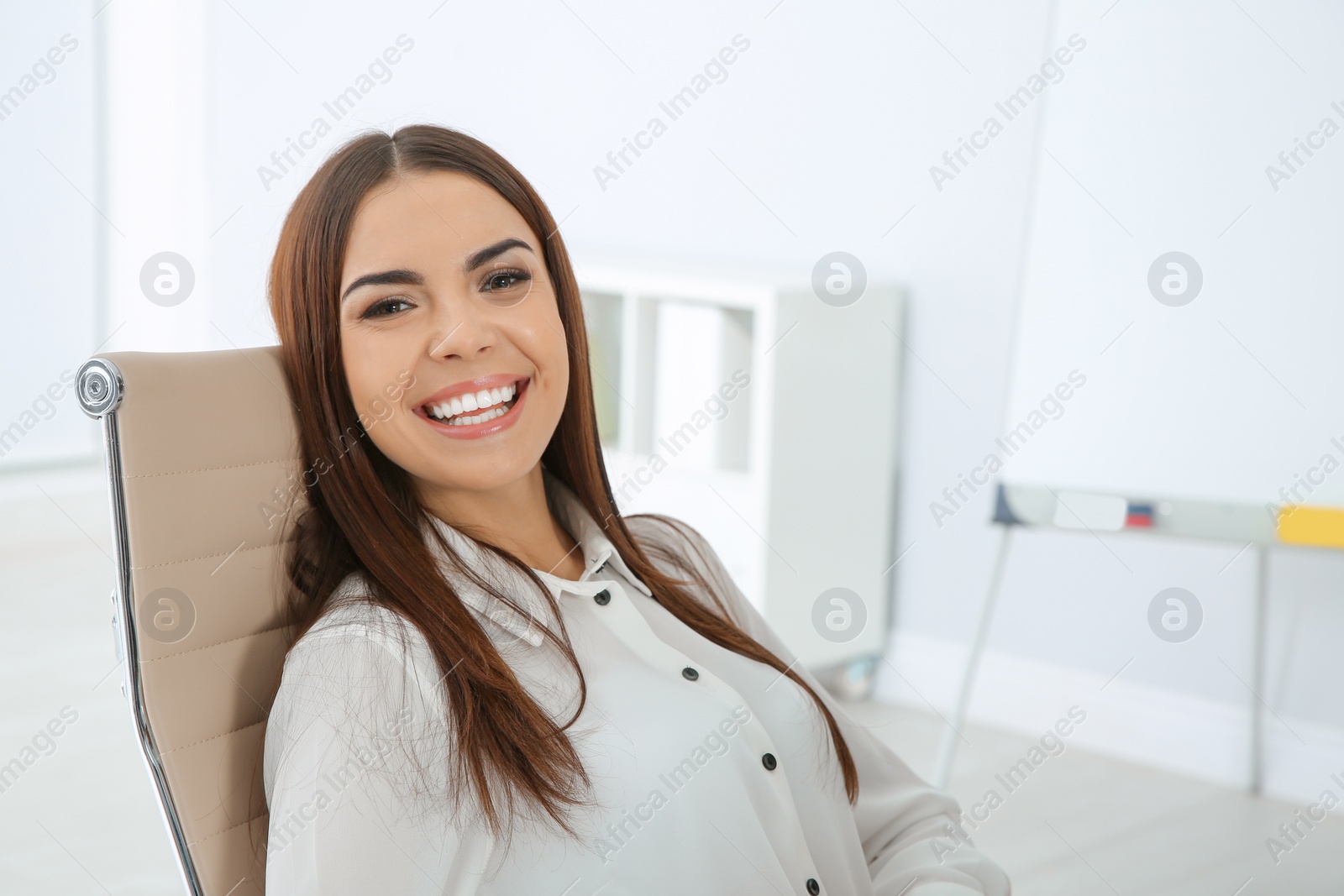 Photo of Portrait of young businesswoman laughing at workplace. Space for text