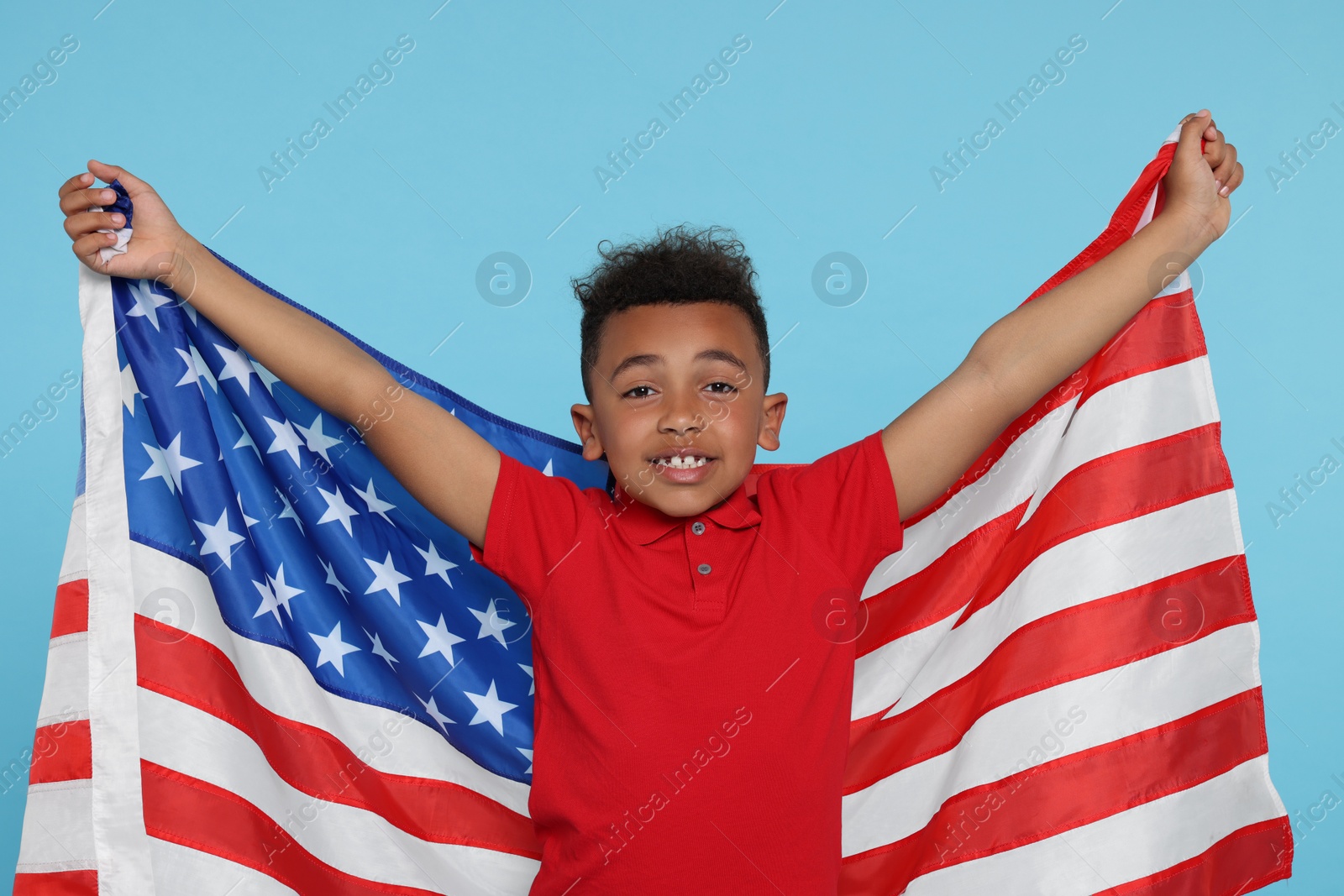 Photo of 4th of July - Independence Day of USA. Happy boy with American flag on light blue background