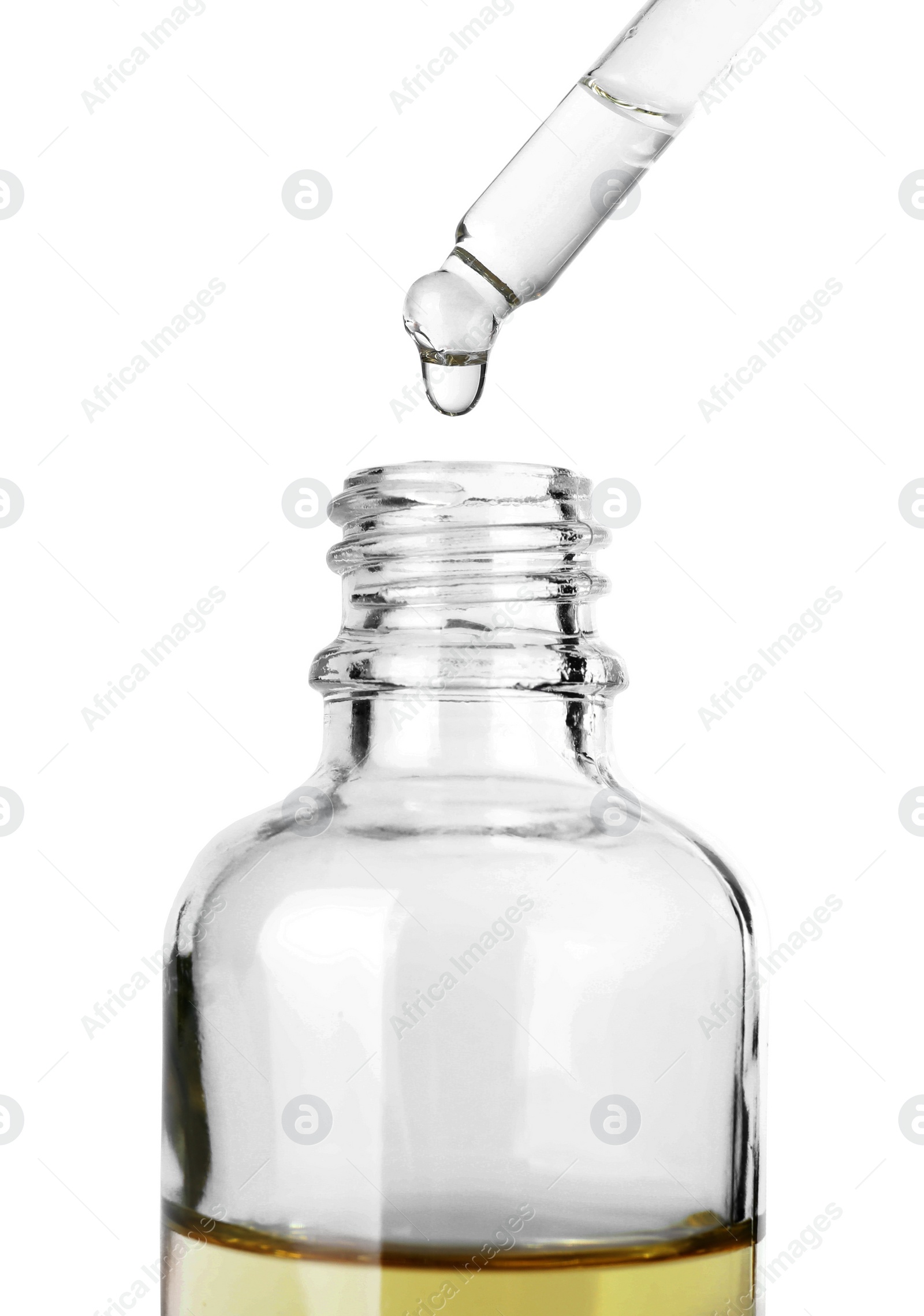 Photo of Dropping herbal essential oil into bottle isolated on white