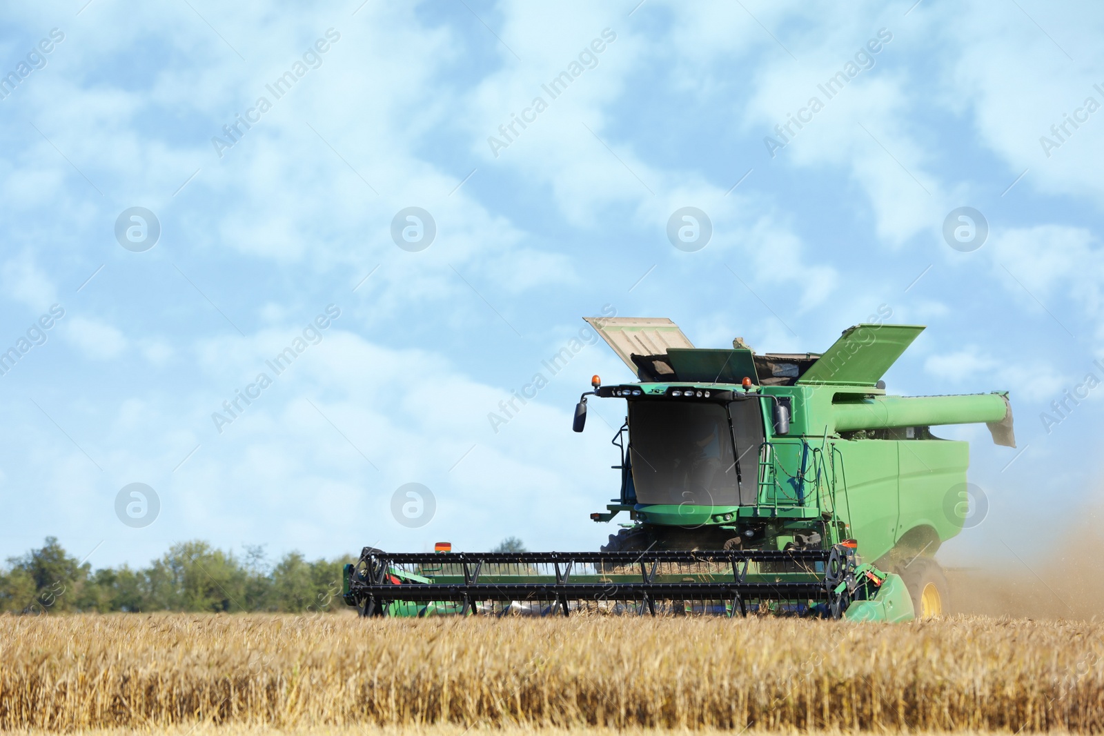 Photo of Modern combine harvester working in agricultural field