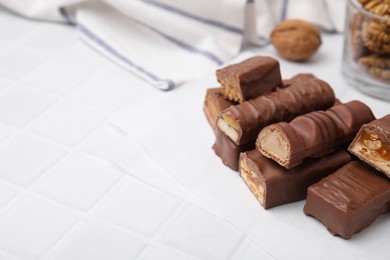 Pieces of different tasty chocolate bars on white tiled table. Space for text