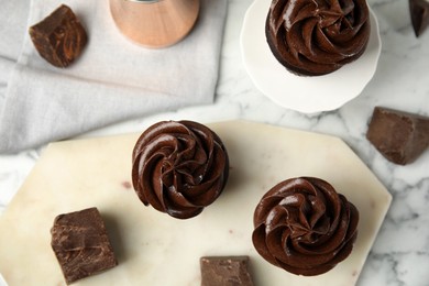 Photo of Flat lay composition with delicious chocolate cupcakes on white marble table