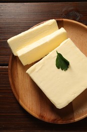 Cut tasty butter on wooden table, top view