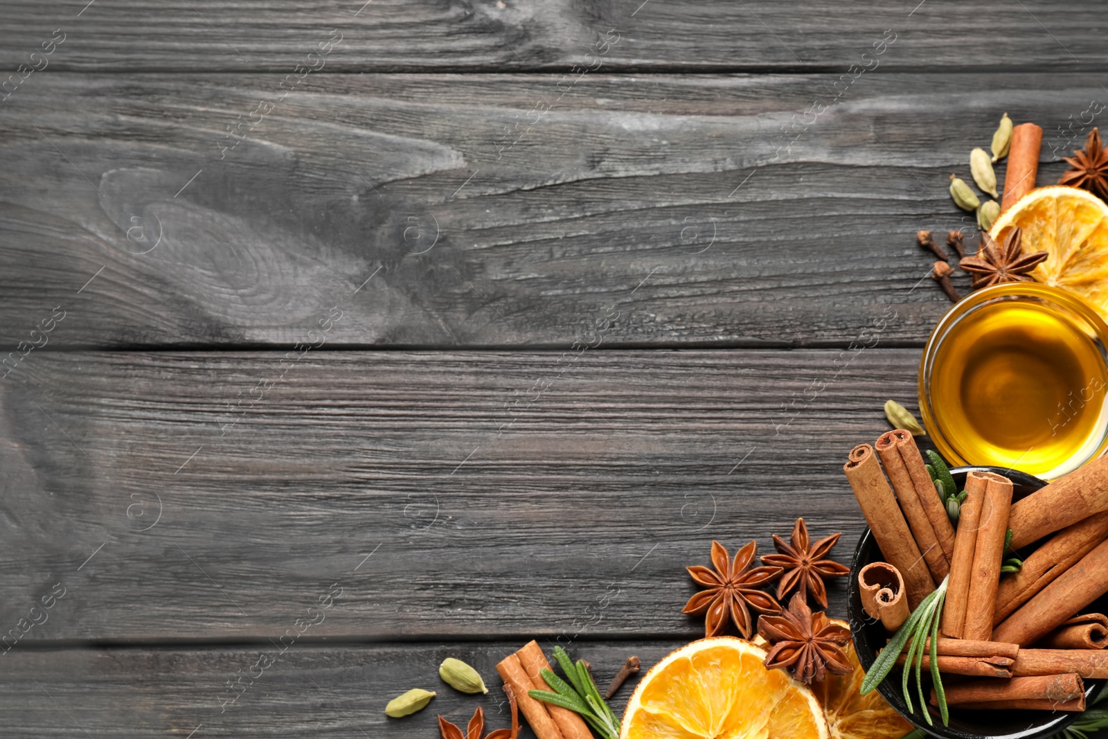 Photo of Flat lay composition with mulled wine ingredients on black wooden table. Space for text