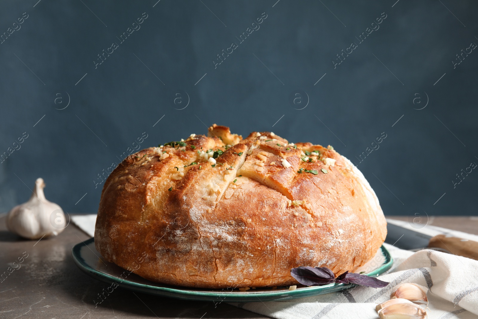 Photo of Plate with delicious homemade garlic bread on table