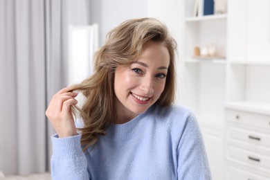 Photo of Portrait of smiling woman with curly hair at home