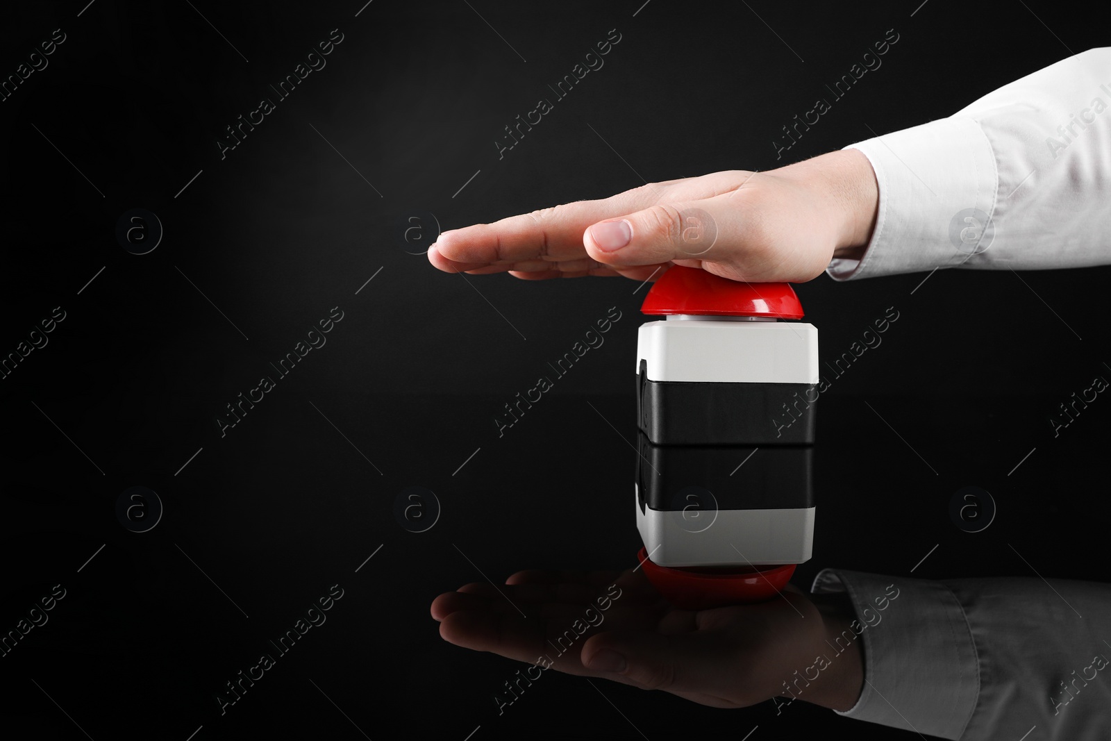 Photo of Man pressing red button of nuclear weapon on black background, closeup with space for text. War concept