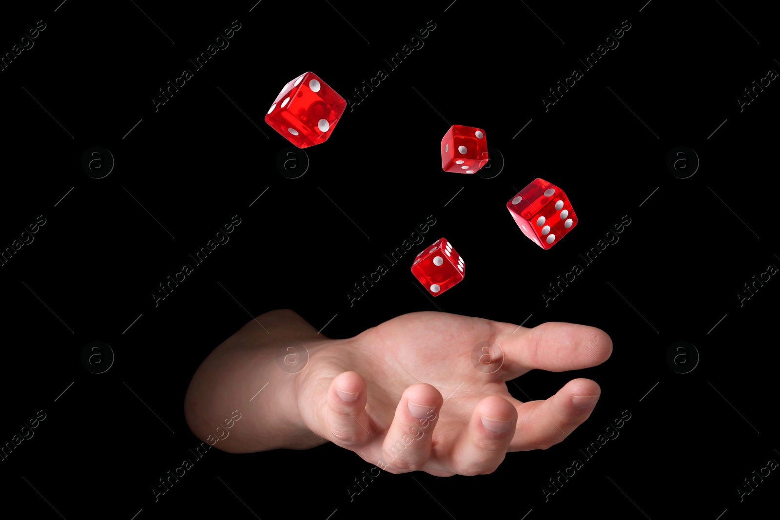 Image of Man throwing red dice on black background, closeup