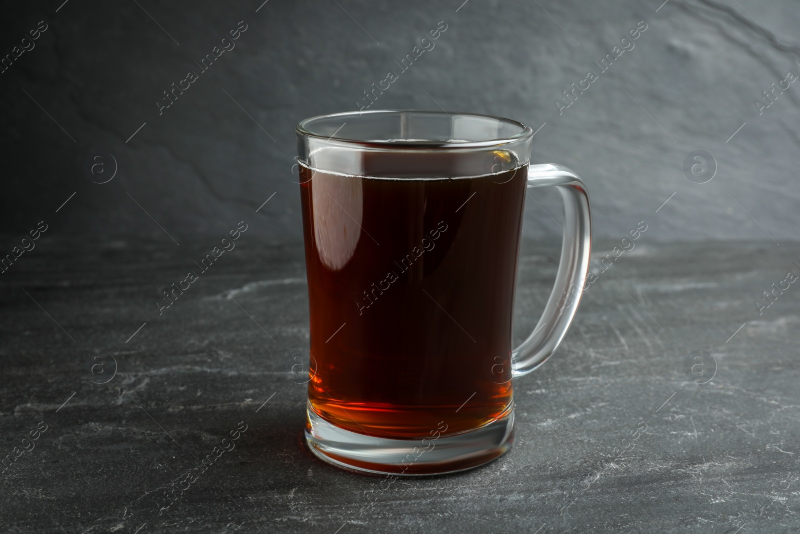 Photo of Mug of delicious kvass in mug on black table