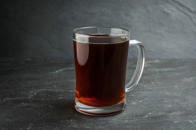 Photo of Mug of delicious kvass in mug on black table