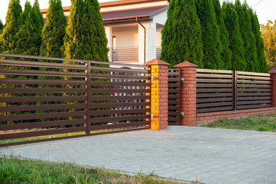 Beautiful brick fence with iron panels outdoors