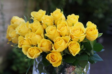 Beautiful bouquet of yellow roses in glass vase outdoors, closeup