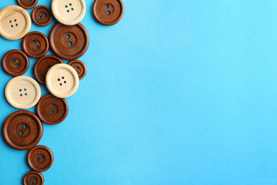 Photo of Many colorful sewing buttons on light blue background, flat lay. Space for text