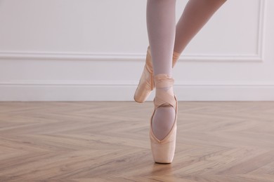 Photo of Little ballerina practicing dance moves in studio, closeup of legs. Space for text