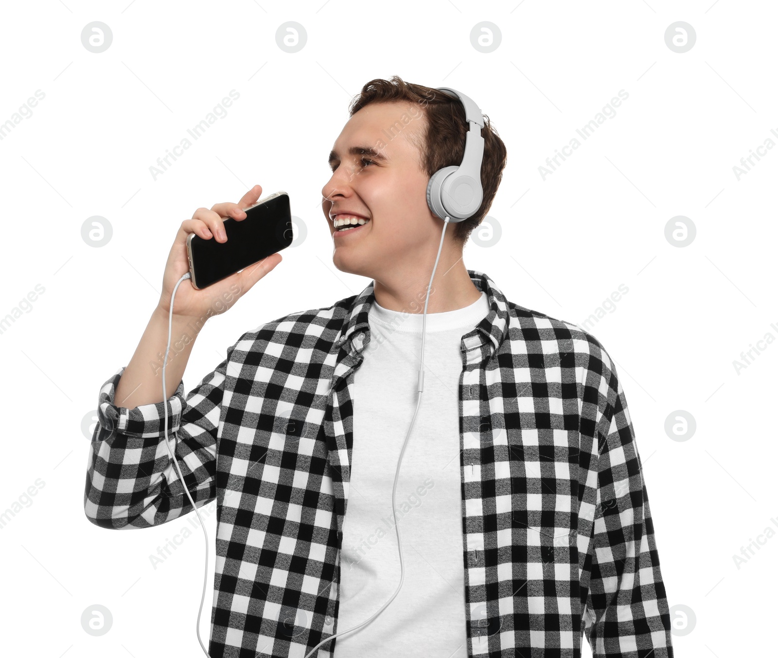 Photo of Handsome young man with headphones and smartphone singing on white background