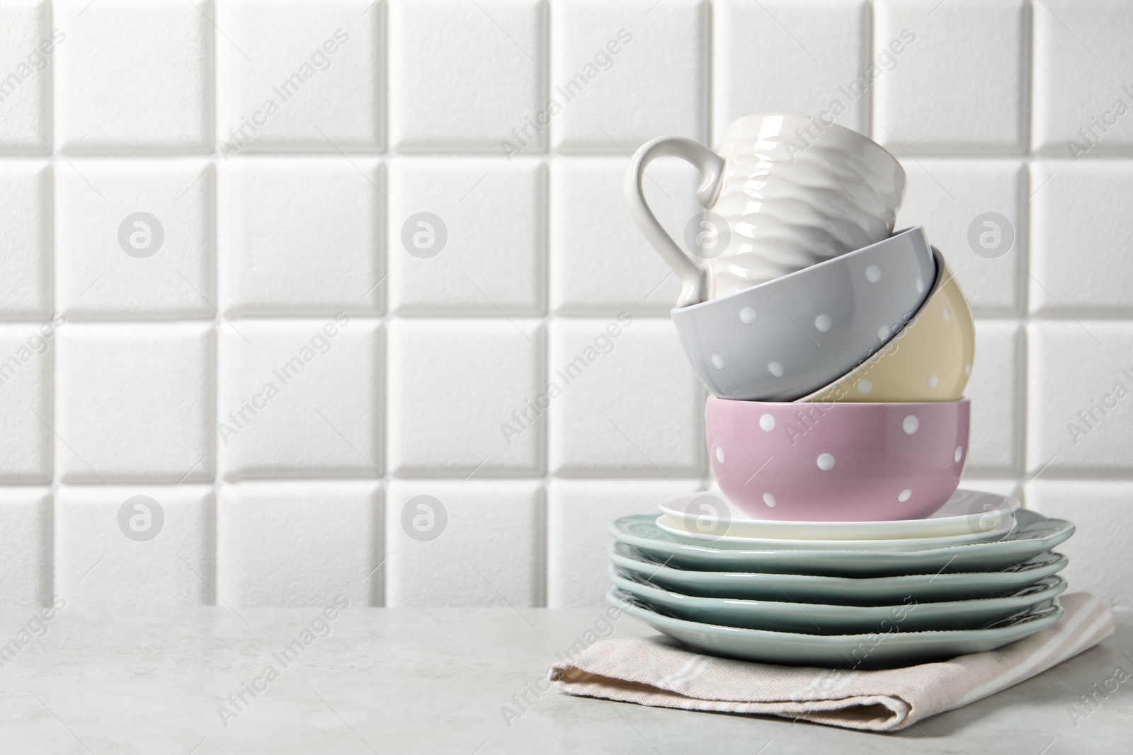 Photo of Beautiful ceramic dishware and cup on light grey table, space for text