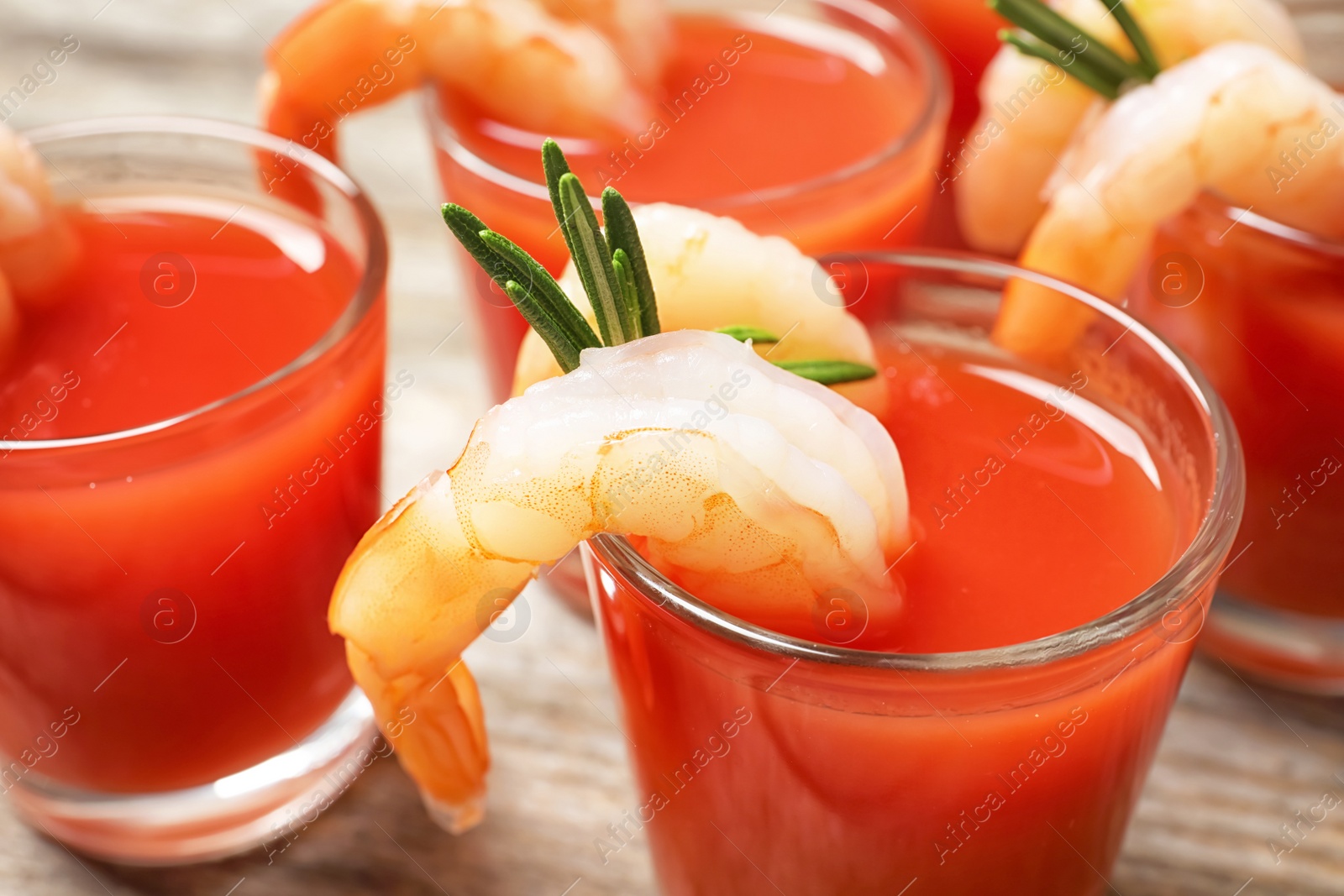 Photo of Delicious shrimp cocktail shots on wooden table