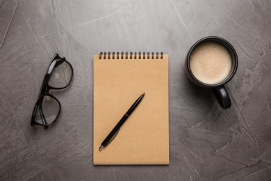 Photo of Flat lay composition with office stationery and cup of coffee on grey stone surface