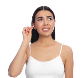 Young woman cleaning ear with cotton swab on white background