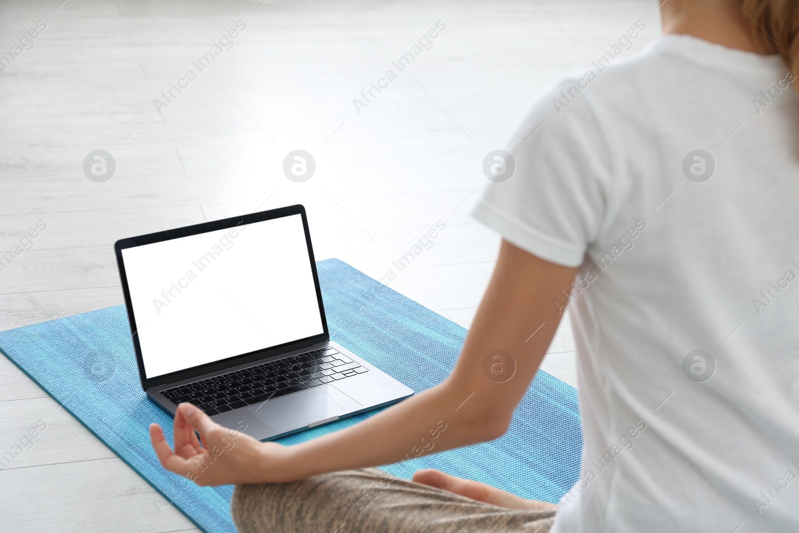 Photo of Woman having online video class via laptop at home, closeup. Distance yoga course during coronavirus pandemic