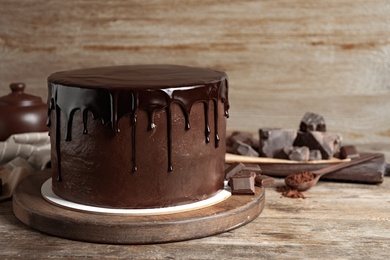 Photo of Freshly made delicious chocolate cake on wooden table. Space for text