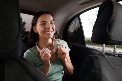 Photo of Young woman with headphones in modern taxi
