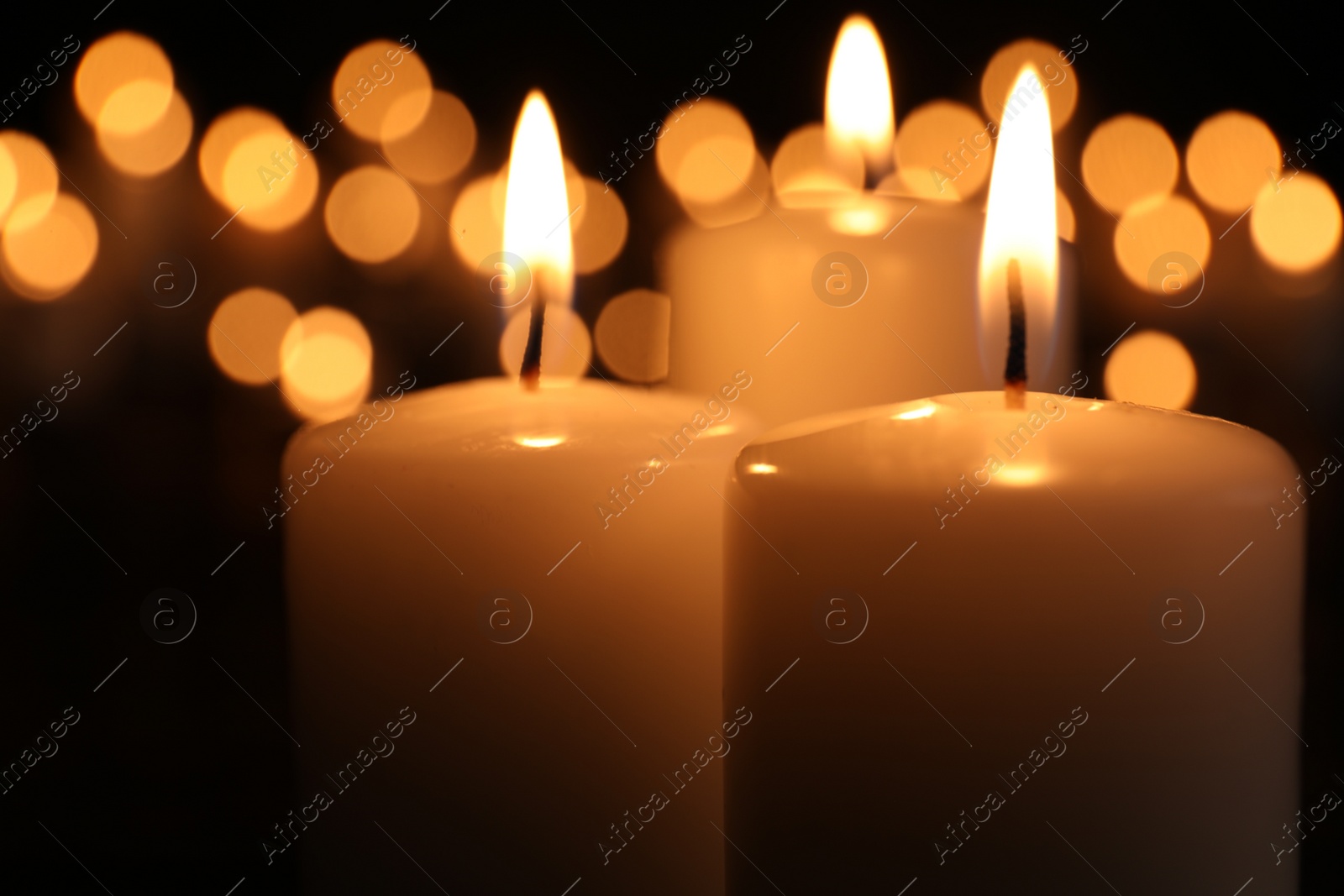 Photo of Burning candles in darkness, closeup. Memory day