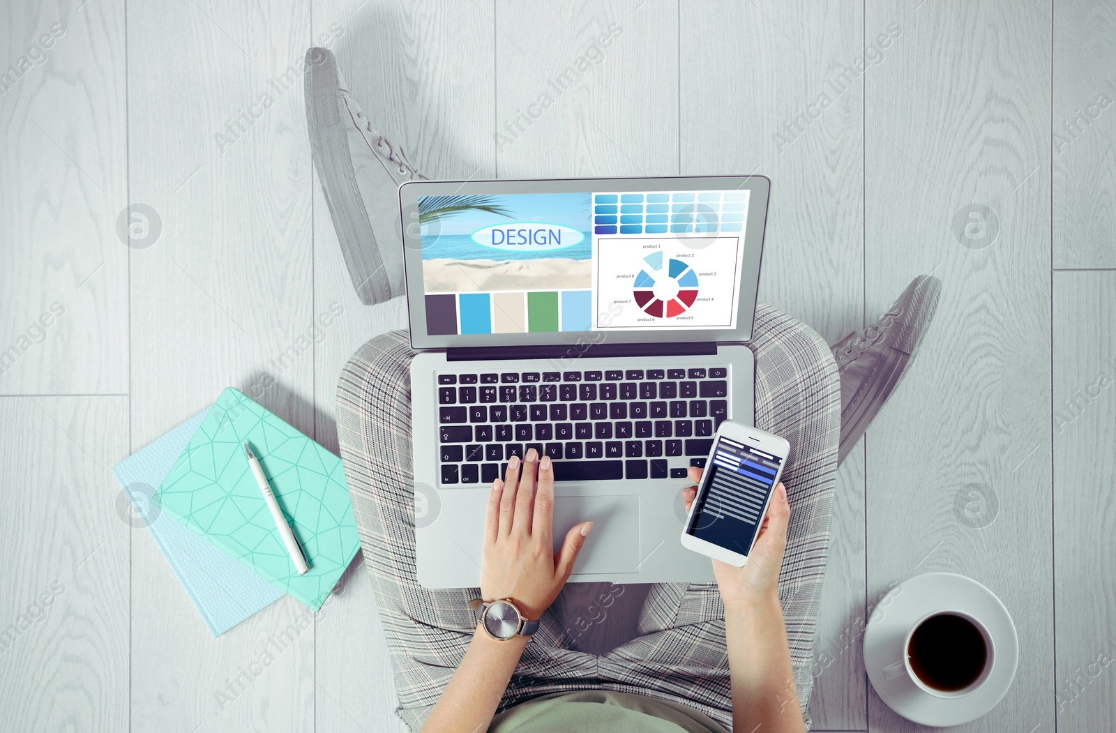 Image of Top view of professional female designer working with laptop sitting on floor, closeup 