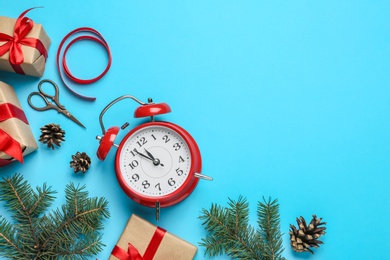 Flat lay composition with Christmas gifts and alarm clock on light blue background, space for text. Boxing day