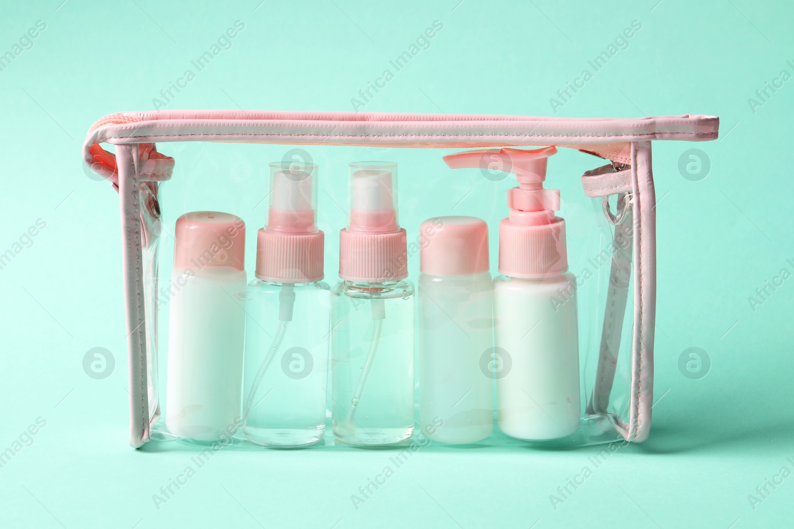 Photo of Cosmetic travel kit in plastic bag on turquoise background. Bath accessories