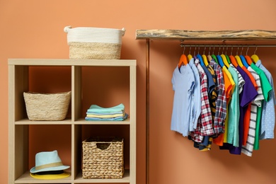 Photo of Different child's clothes hanging on rack in room
