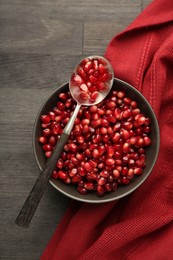 Tasty ripe pomegranate grains on dark wooden table, top view