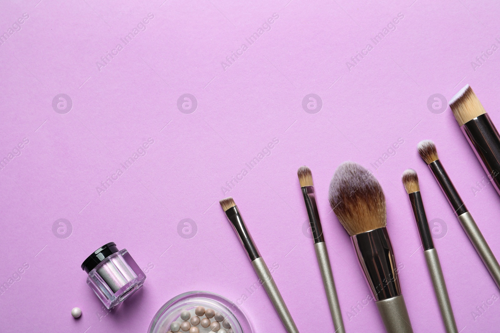 Photo of Flat lay composition with makeup brushes on lilac background. Space for text