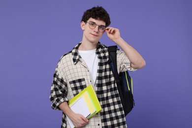 Photo of Portrait of student with backpack and notebooks on purple background