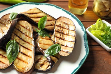 Photo of Plate with fried eggplant slices on table, closeup