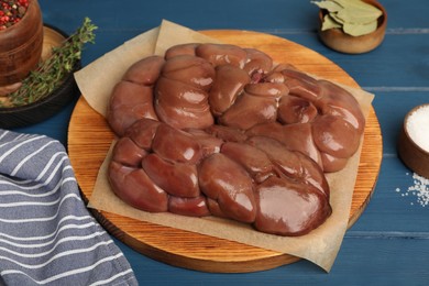 Photo of Fresh raw kidney meat, spices and thyme on blue wooden table