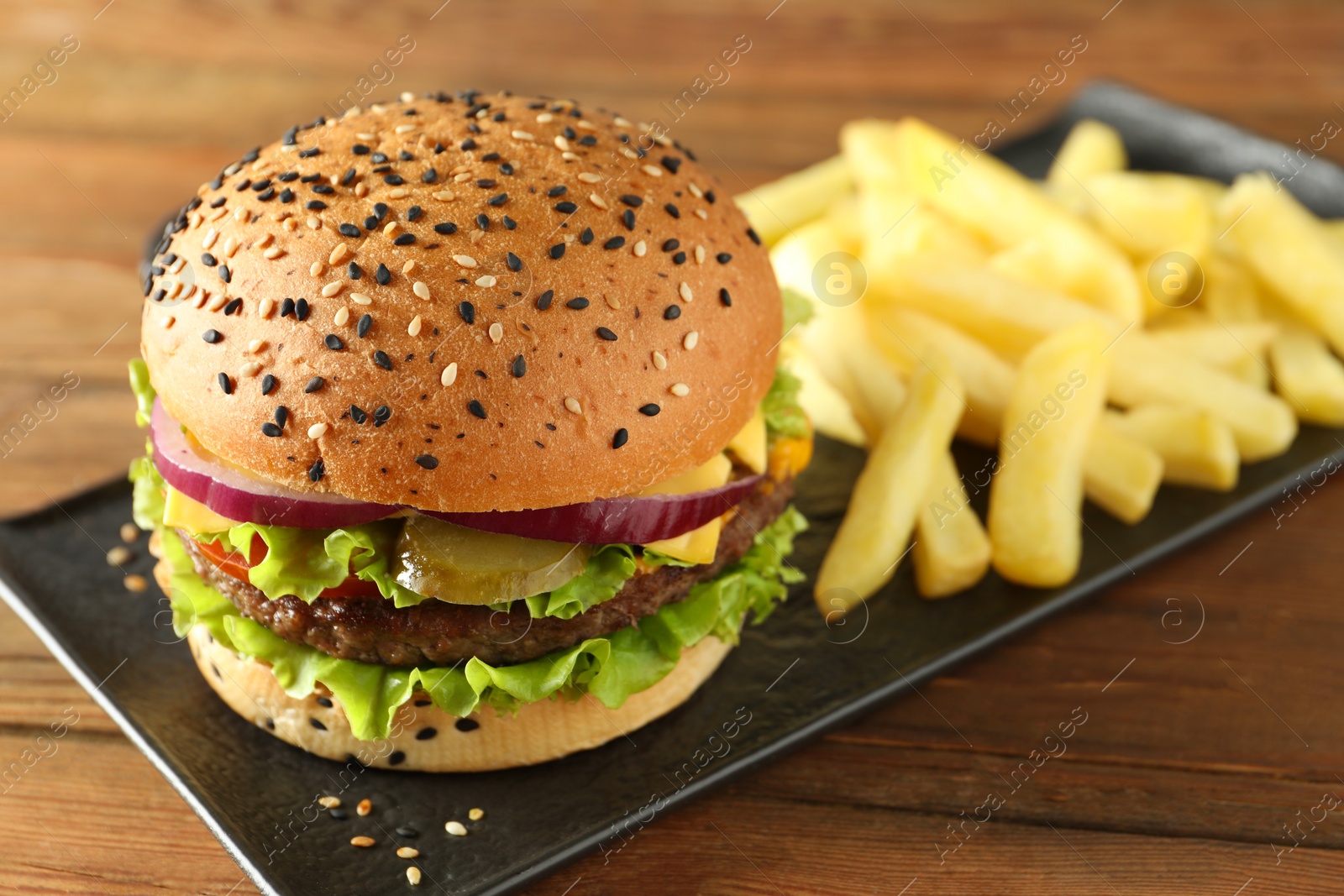 Burger with delicious patty and french fries on wooden table, closeup Photo of Burger with delicious patty and french fries on wooden table, closeup
