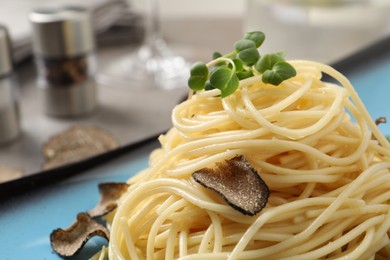 Photo of Delicious pasta with truffle slices and microgreens on plate, closeup