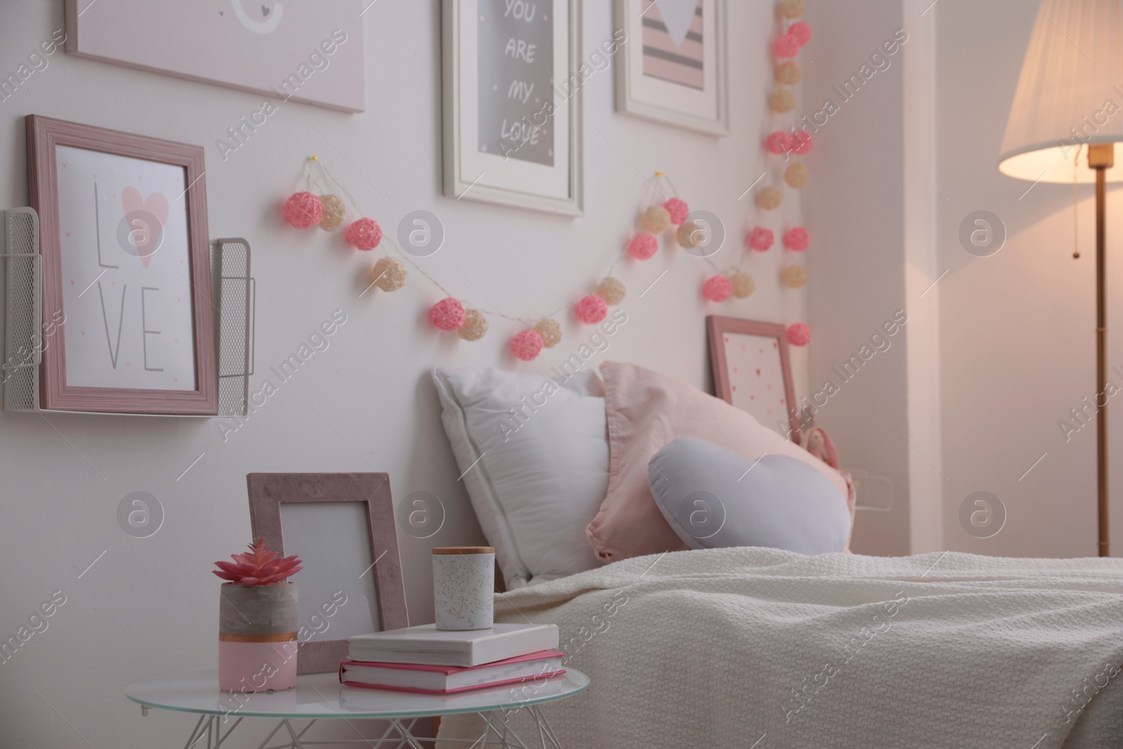 Photo of Modern teenager's room interior with comfortable bed and beautiful pictures