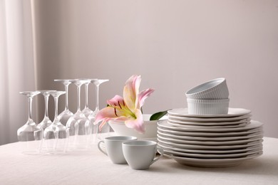 Photo of Set of clean dishware and wine glasses on table indoors