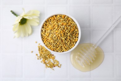 Flat lay composition with fresh bee pollen granules and honey on white tiled table