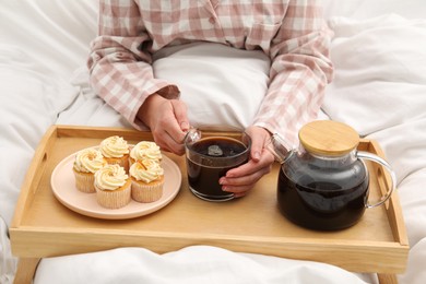 Photo of Woman with cup of hot drink in bed, closeup